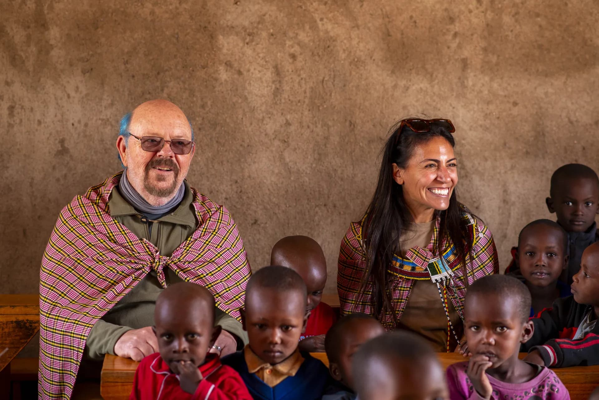 Safari guests sitting with schoolchildren