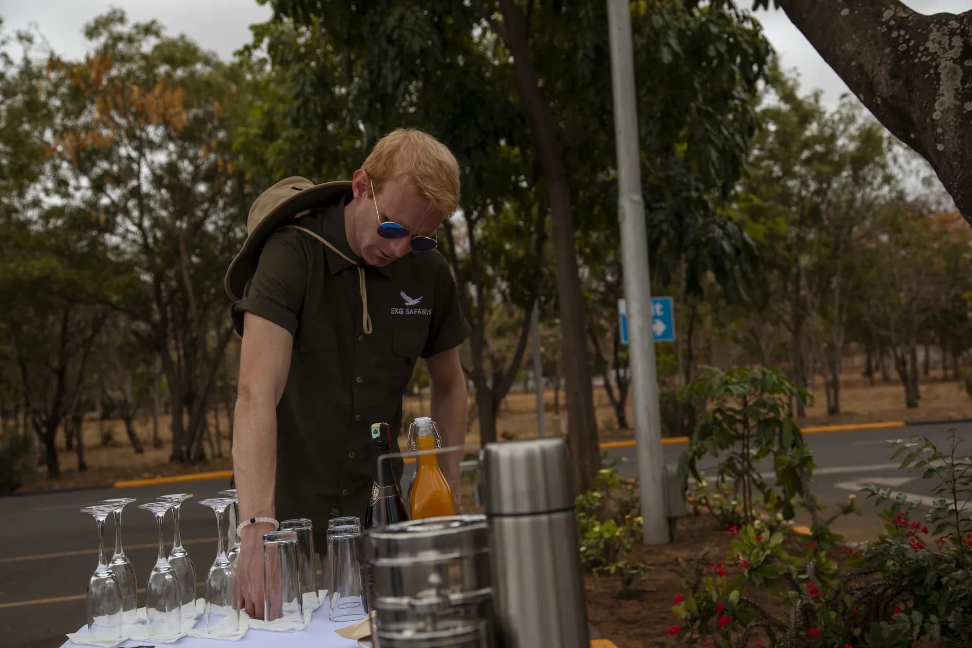 An EXG guide setting out drinks for guests at a private sundowner spot